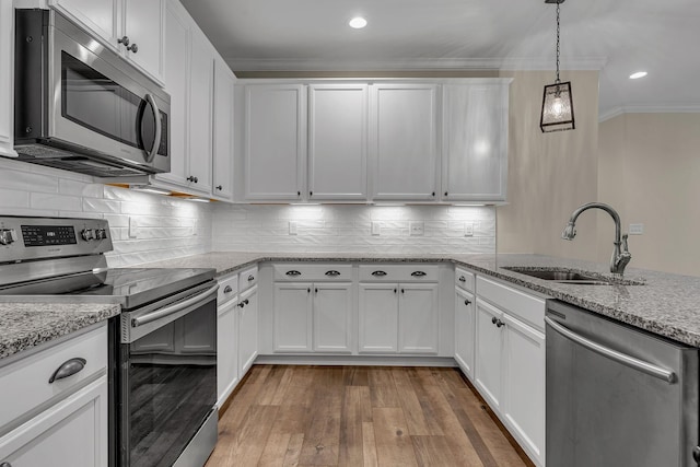 kitchen featuring light stone counters, stainless steel appliances, sink, and white cabinets