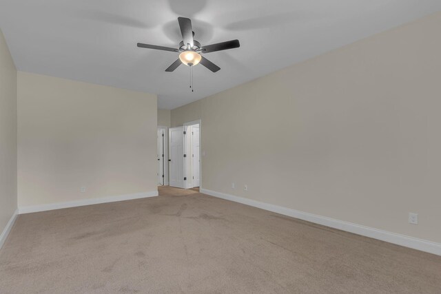 carpeted spare room with ceiling fan