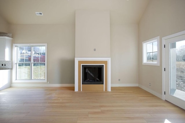 unfurnished living room featuring a wealth of natural light and light hardwood / wood-style floors