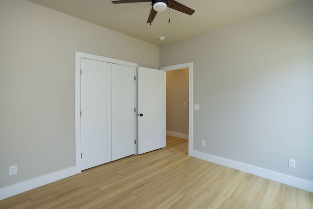 unfurnished bedroom with a closet, a ceiling fan, baseboards, and light wood finished floors
