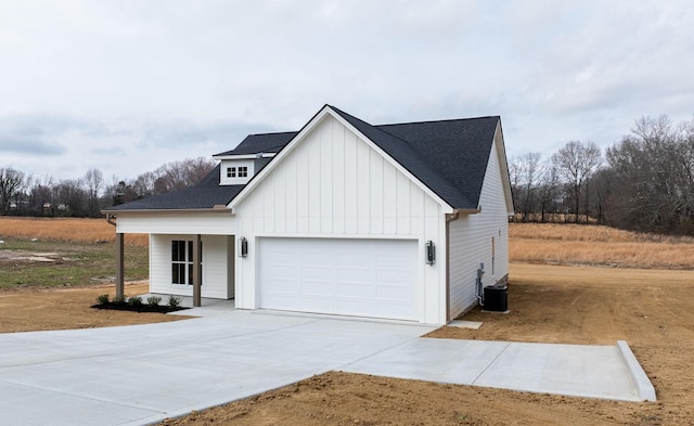 modern inspired farmhouse with concrete driveway, an attached garage, board and batten siding, and a shingled roof