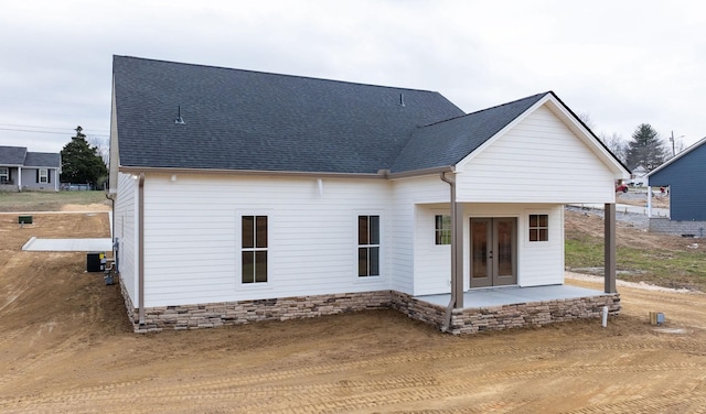 back of house featuring french doors, roof with shingles, and a patio area