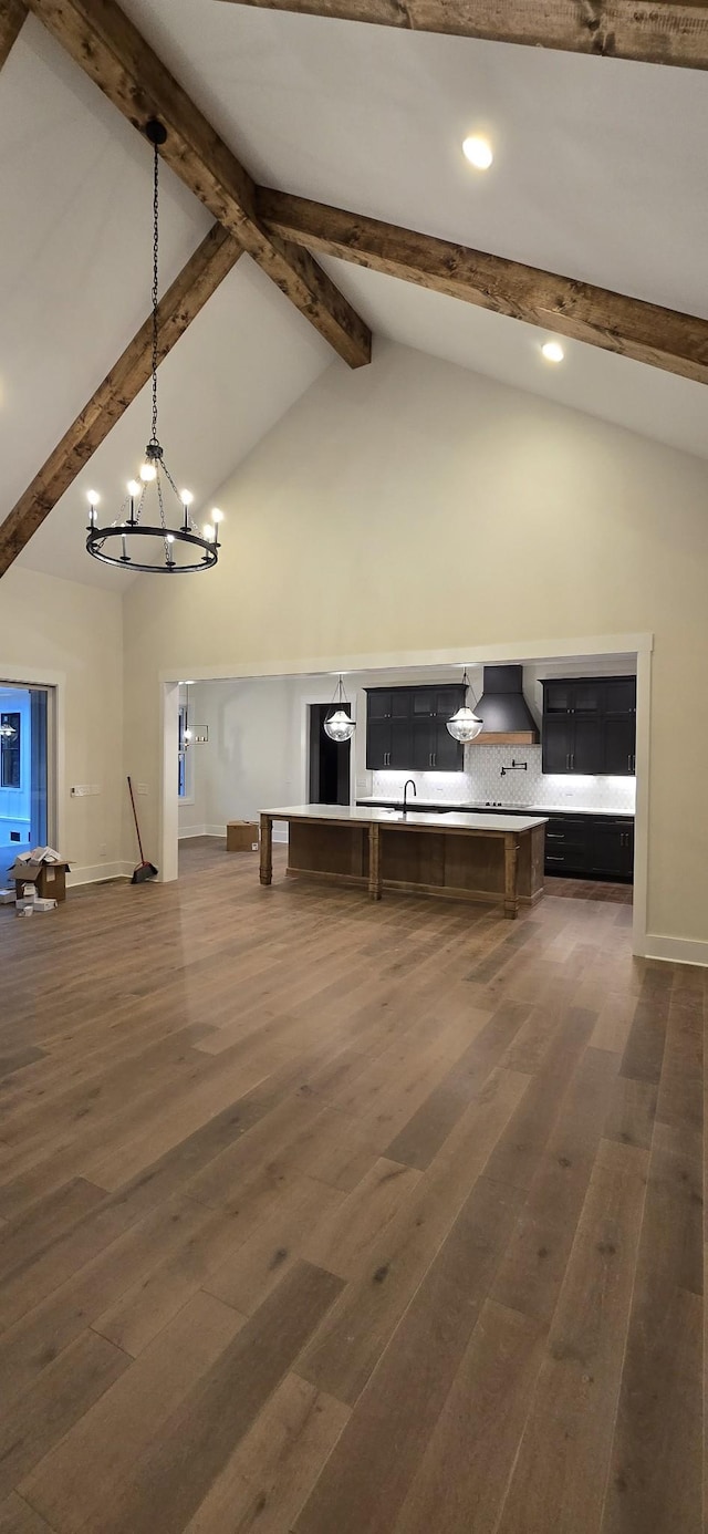 unfurnished living room with beam ceiling, dark wood-type flooring, and high vaulted ceiling