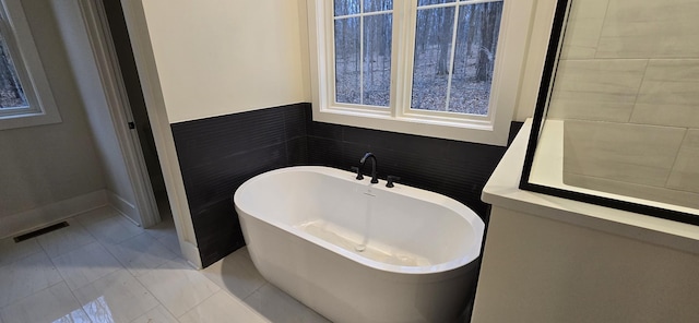 bathroom with tile walls and a bath