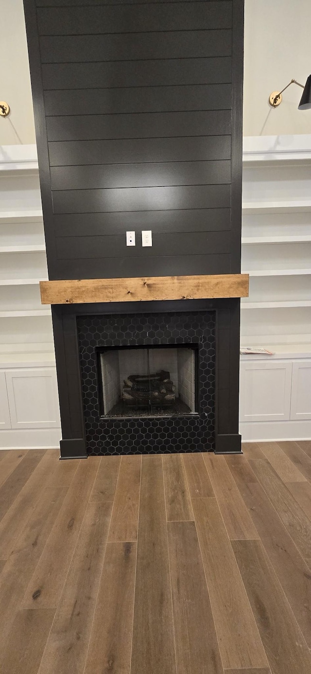 room details with hardwood / wood-style floors, a fireplace, and built in shelves