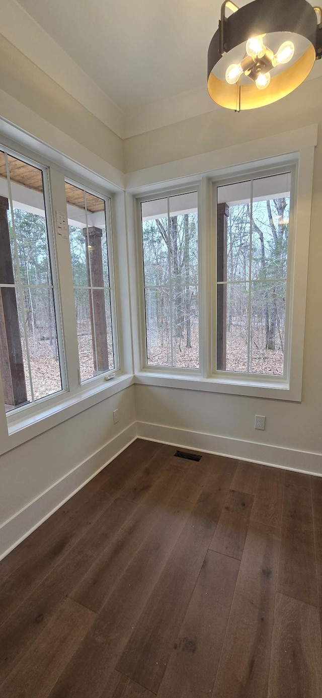 unfurnished dining area with dark wood-type flooring and a wealth of natural light