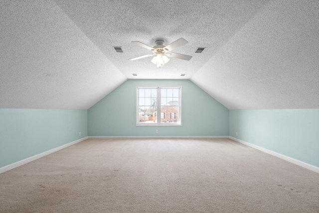 additional living space with baseboards, visible vents, a ceiling fan, lofted ceiling, and carpet floors