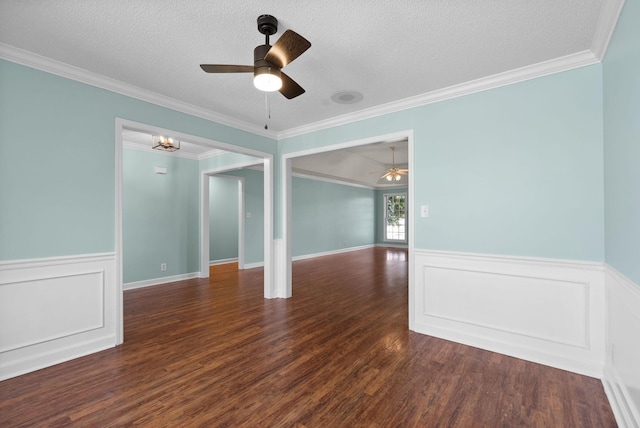 unfurnished room featuring a textured ceiling, dark wood-style flooring, and wainscoting