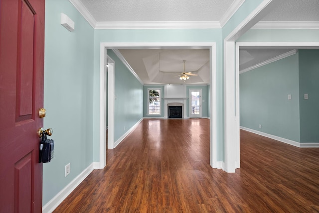 unfurnished living room with ceiling fan, a fireplace, crown molding, and wood finished floors