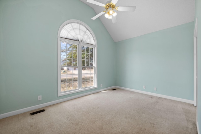 carpeted spare room featuring high vaulted ceiling, baseboards, visible vents, and a ceiling fan