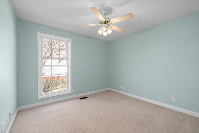 unfurnished room with carpet, a textured ceiling, baseboards, and a ceiling fan