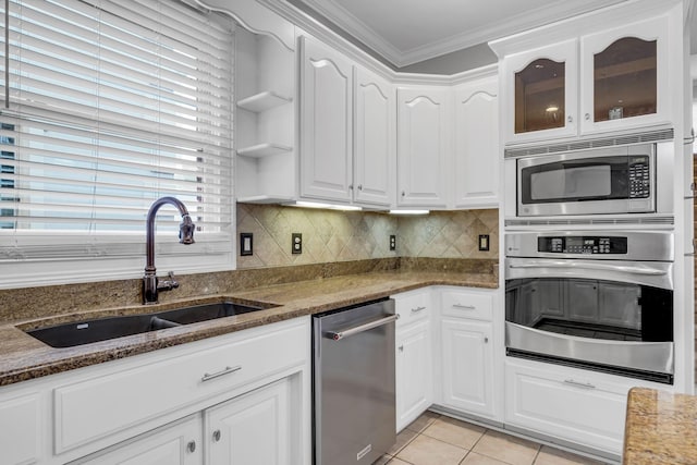 kitchen featuring stainless steel appliances, sink, white cabinets, and dark stone counters