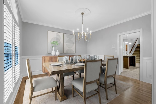 dining room with crown molding, a wealth of natural light, and light wood-type flooring