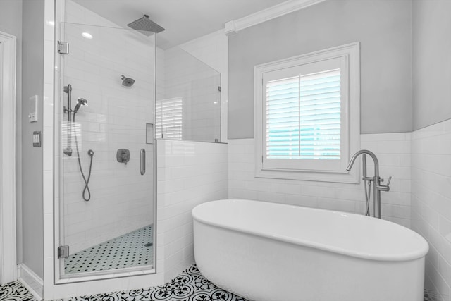 bathroom with shower with separate bathtub and tile walls