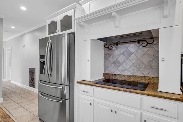 kitchen featuring crown molding, stainless steel fridge, white cabinetry, dark stone countertops, and black electric cooktop