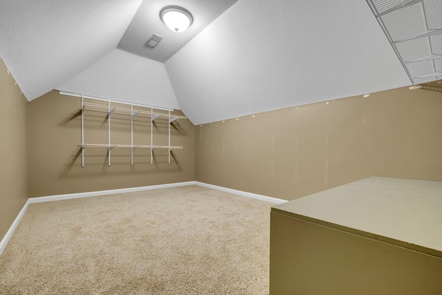 walk in closet with lofted ceiling and carpet floors