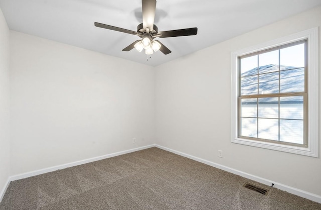 carpeted empty room with a wealth of natural light and ceiling fan