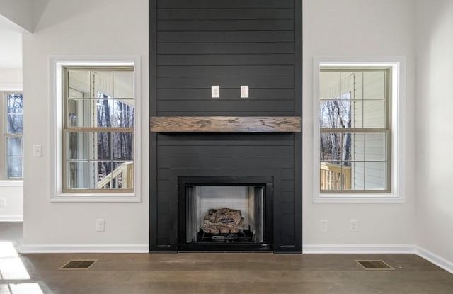 interior details with hardwood / wood-style flooring and a large fireplace