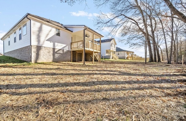 rear view of property featuring a wooden deck and ceiling fan