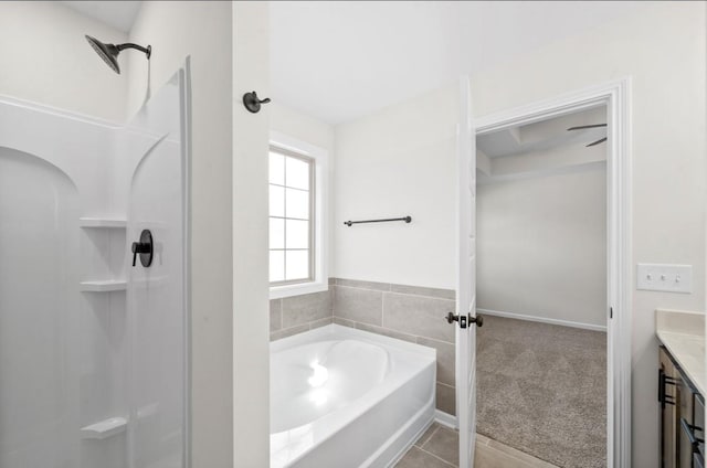 bathroom with tile patterned flooring, vanity, and a tub