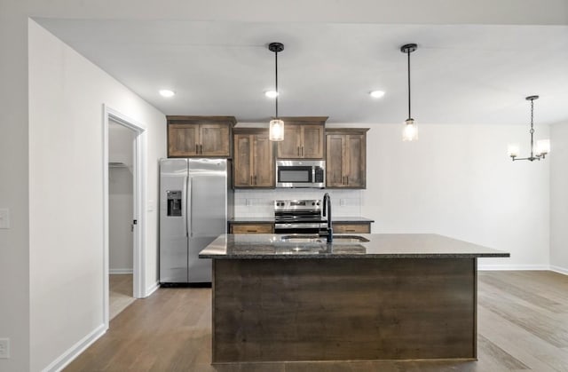 kitchen with stainless steel appliances, decorative light fixtures, sink, and decorative backsplash