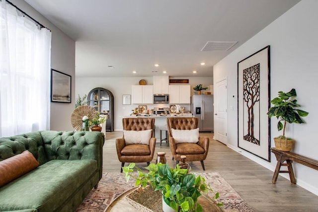 living room with plenty of natural light and light hardwood / wood-style flooring