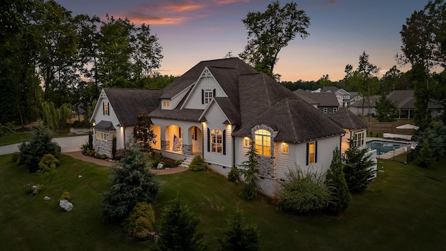 back house at dusk with a lawn