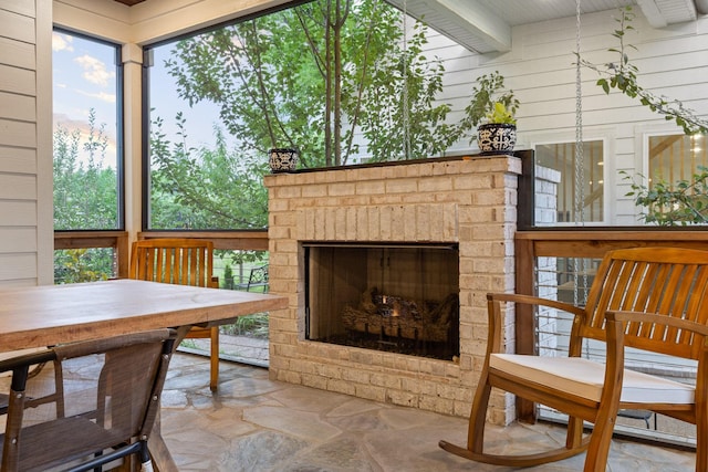 sunroom with a fireplace and beamed ceiling