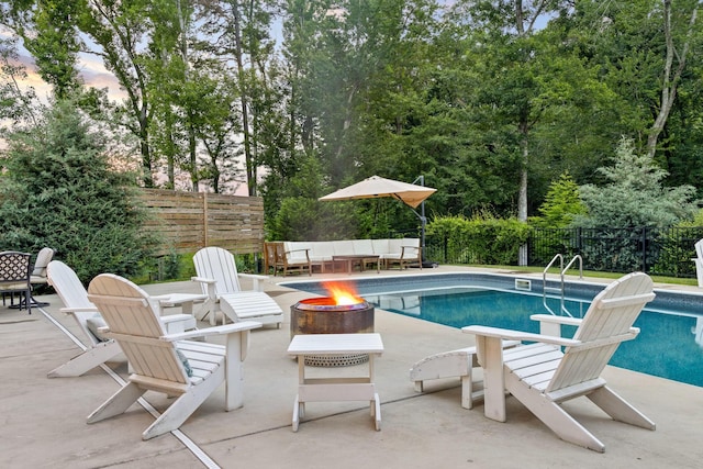 view of swimming pool with a patio and a fire pit