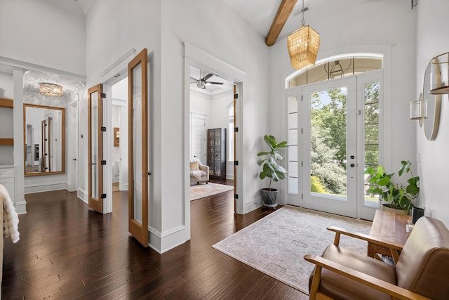 entrance foyer featuring a high ceiling, plenty of natural light, dark hardwood / wood-style floors, and beam ceiling