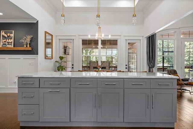 bar featuring gray cabinets, pendant lighting, crown molding, light stone countertops, and dark wood-type flooring