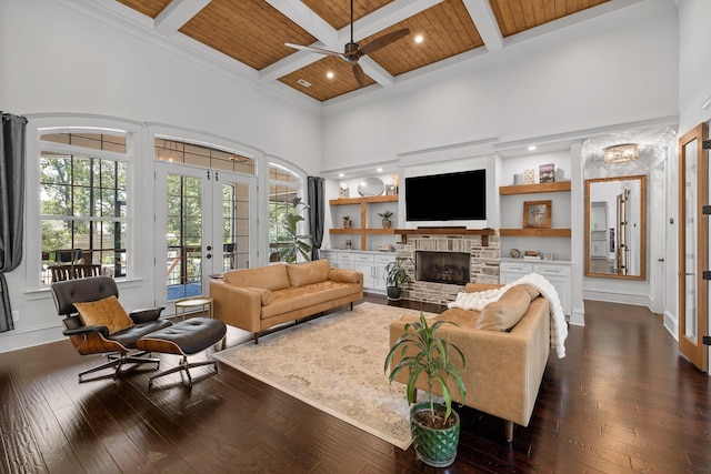 living room featuring a towering ceiling, a fireplace, dark hardwood / wood-style flooring, wood ceiling, and french doors