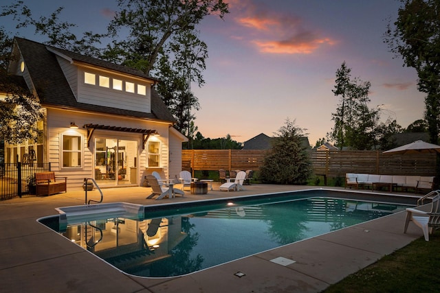 pool at dusk featuring a patio