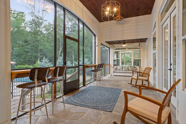 sunroom / solarium with a chandelier and wooden ceiling