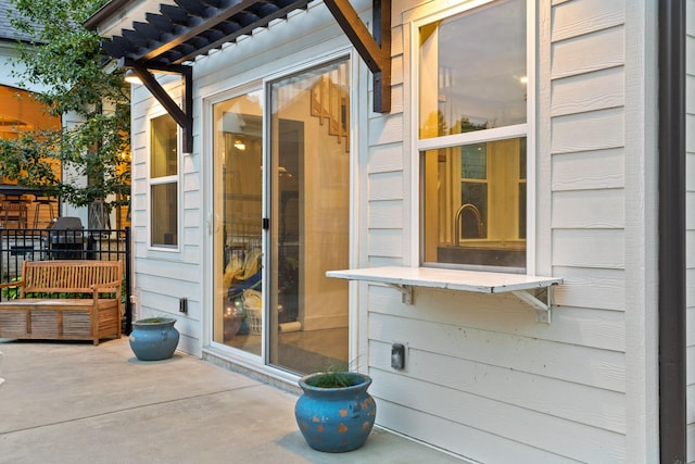 doorway to property featuring a pergola and a patio