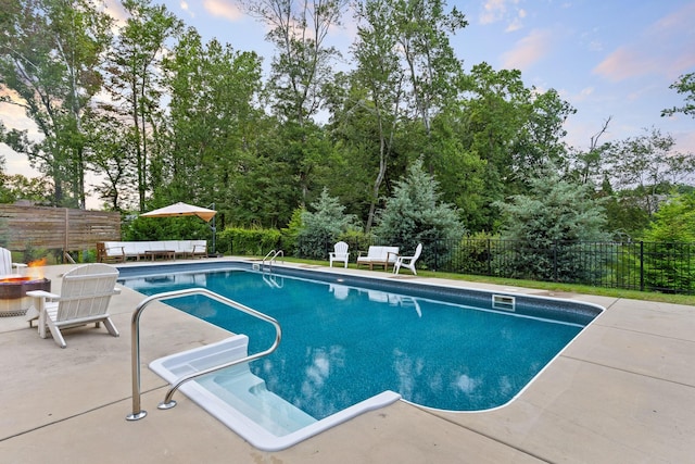 view of swimming pool with a patio area and an outdoor fire pit