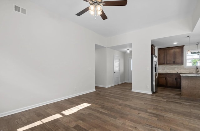 unfurnished living room with ceiling fan and dark hardwood / wood-style flooring