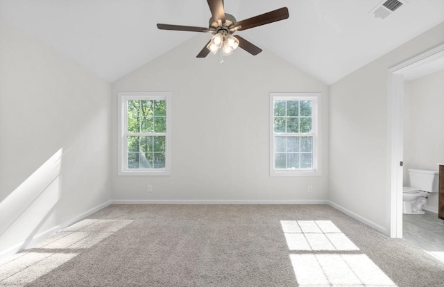 carpeted empty room with vaulted ceiling, a wealth of natural light, and ceiling fan