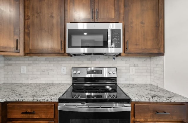 kitchen with light stone counters, tasteful backsplash, and stainless steel appliances