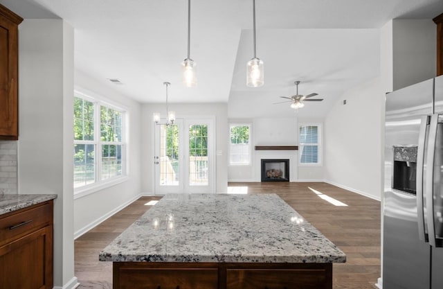 kitchen with dark hardwood / wood-style flooring, hanging light fixtures, a center island, and stainless steel refrigerator with ice dispenser