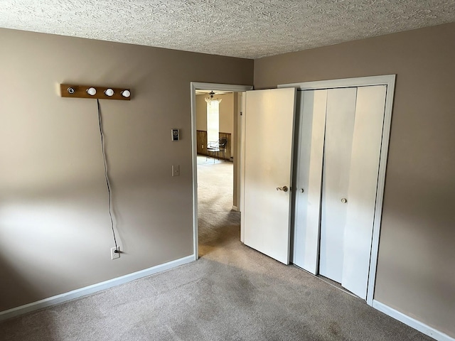 unfurnished bedroom with a closet, carpet flooring, and a textured ceiling