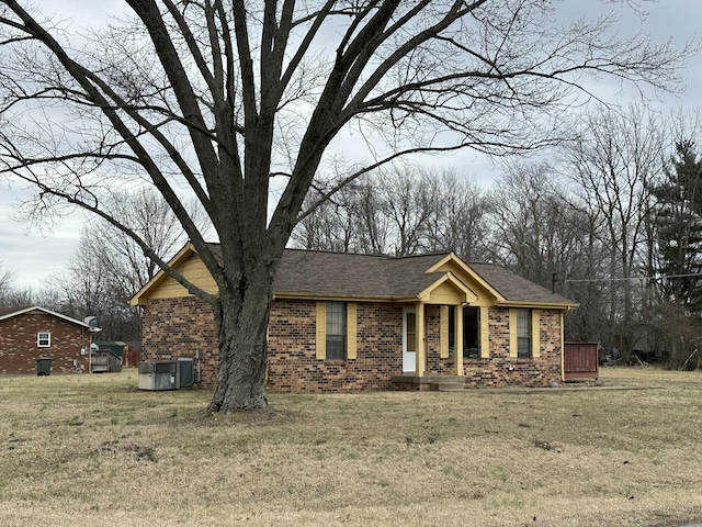 view of front facade with a front yard and central air condition unit