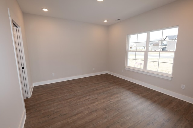 unfurnished room with recessed lighting, visible vents, dark wood finished floors, and baseboards