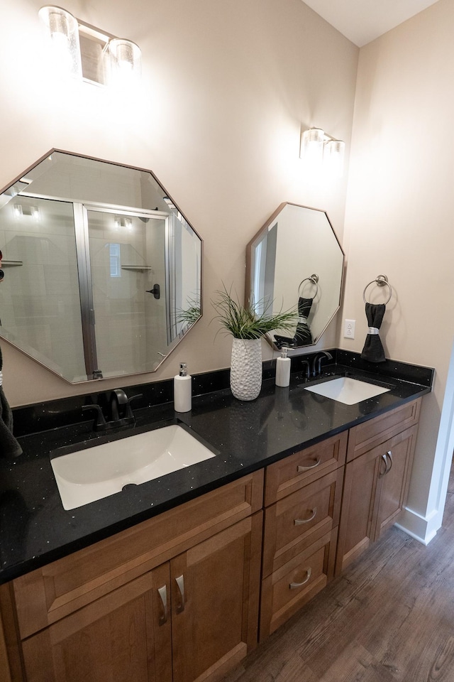 bathroom featuring hardwood / wood-style flooring, vanity, and a shower with door