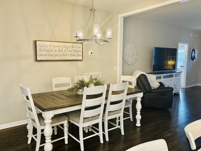 dining area with dark wood-type flooring and an inviting chandelier