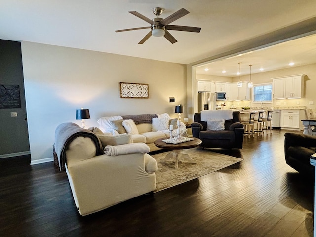 living room with ceiling fan, sink, and dark hardwood / wood-style flooring