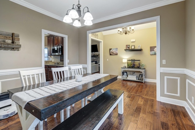 dining room featuring crown molding, a notable chandelier, and dark hardwood / wood-style flooring