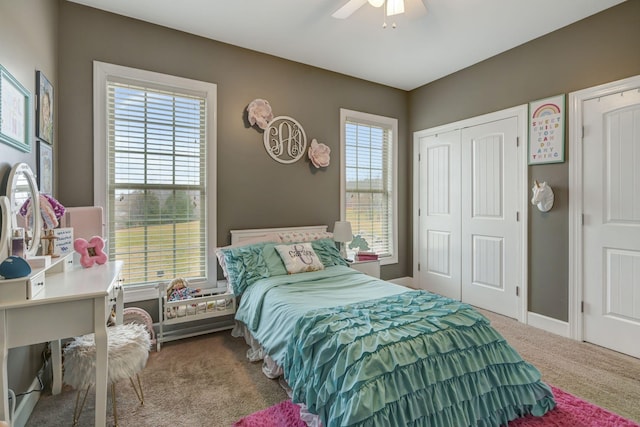 carpeted bedroom with multiple windows, ceiling fan, and a closet