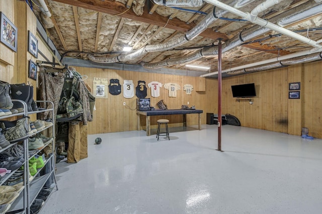 basement featuring wood walls