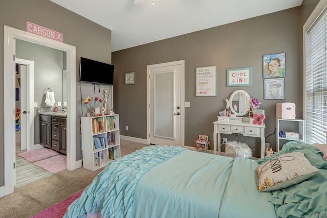 bedroom featuring ensuite bath and light colored carpet